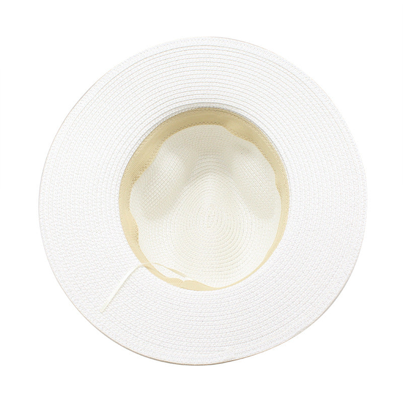 Underside of the white wide brim straw hat showing the crown and inner band