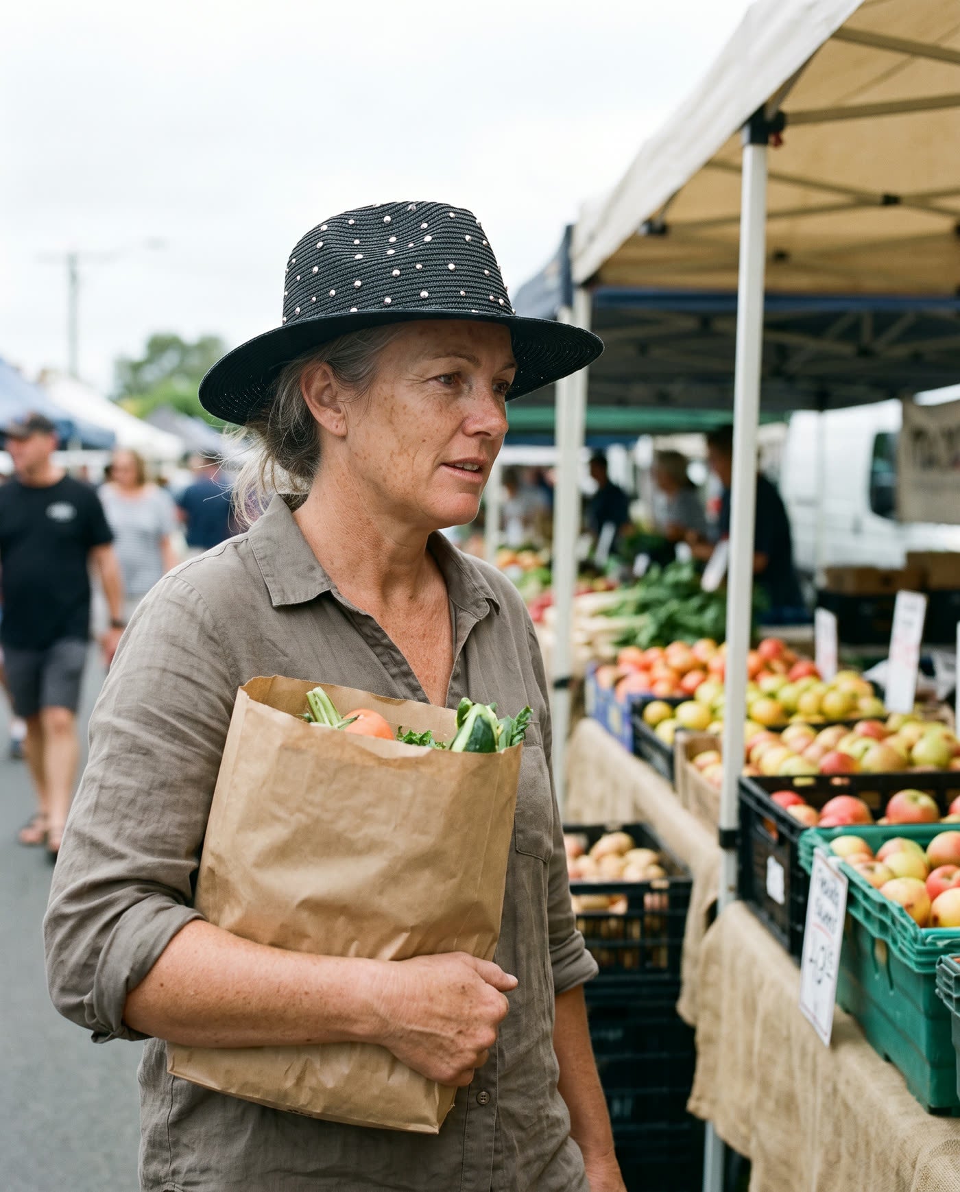 Woman wearing the straw hat while shopping at a farmers market