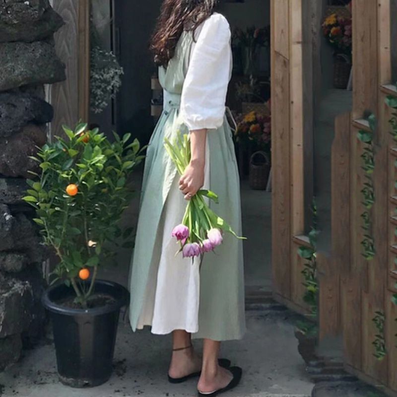 Woman holding tulips outside a flower shop wearing the garden apron