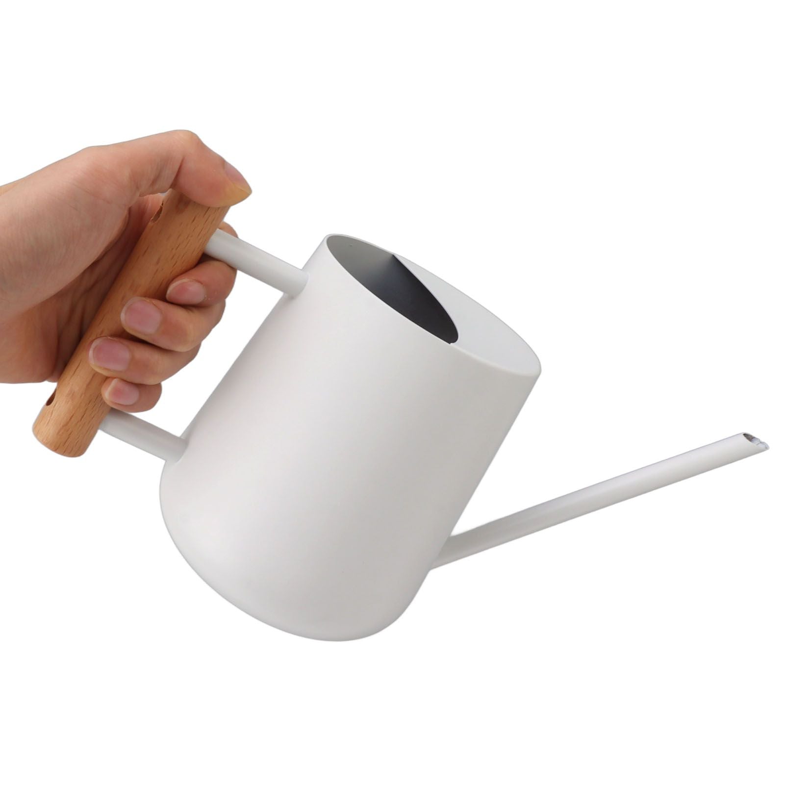 Hand holding the white watering can by its wooden handle