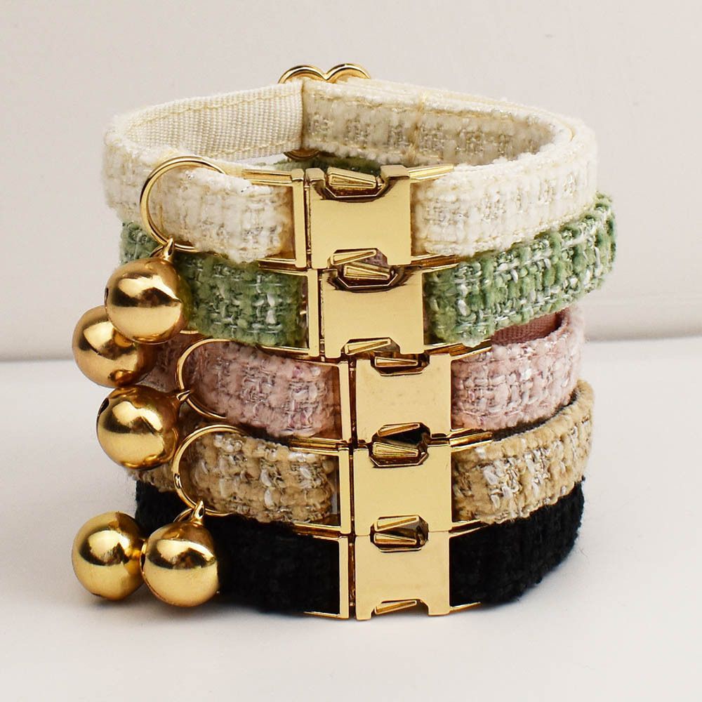 The tweed pet collar range stacked together showing every colourway with gold bells and buckles
